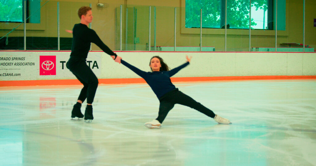 Madison Chock and Evan Bates skating together on the ice rink.