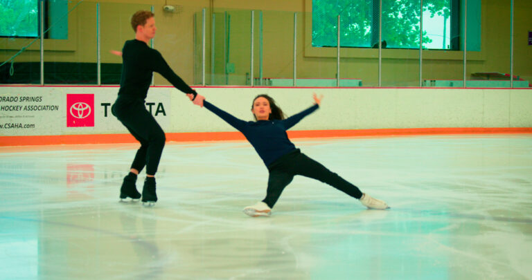 Madison Chock and Evan Bates skating together on the ice rink.