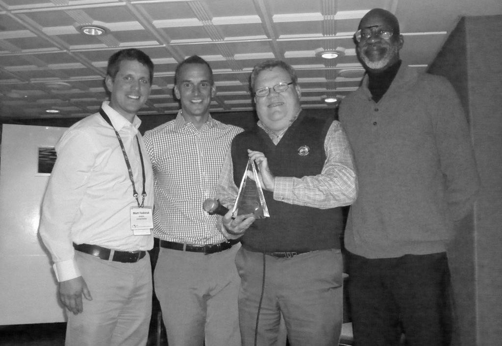 Matt Fedoruk, Travis Tygart, and Edwin Moses giving an award to Larry Bowers.