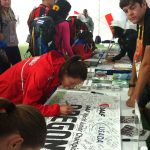 An athlete signing a USADA poster.