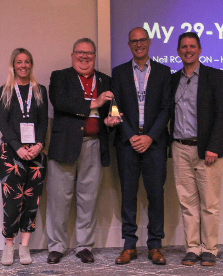 Neil Robinson, Ph.D.  receiving his award from Laura Lewis, Matt Fedoruk, and Larry Bowers.