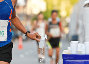 Runner grabbing a cup of water during a competition.