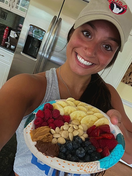 Abby Raymond holding a plate of berries and nuts.