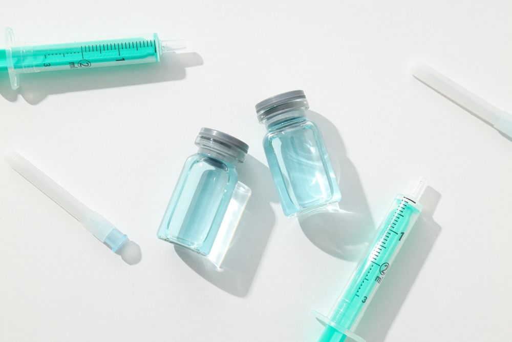 Two glass ampule bottles next to syringes.