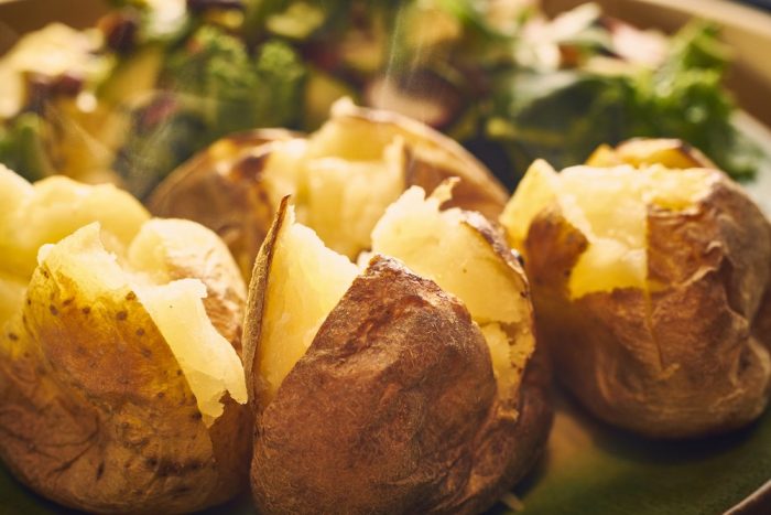 Cut open baked potatoes.