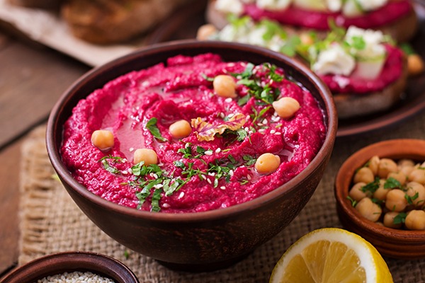 Beet hummus with whole chickpeas on top.