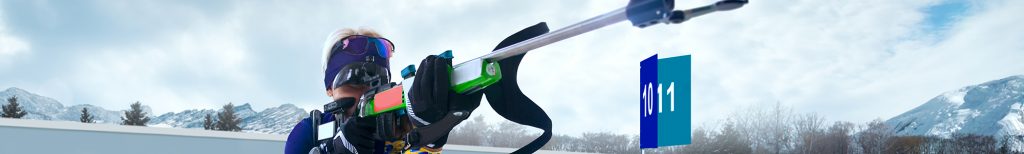 Woman competing in a biathlon taking aim with airgun during competition.