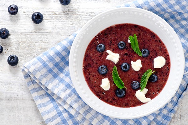 Blueberry soup in a white bowl.