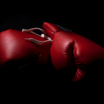 two boxing gloves in the shadows