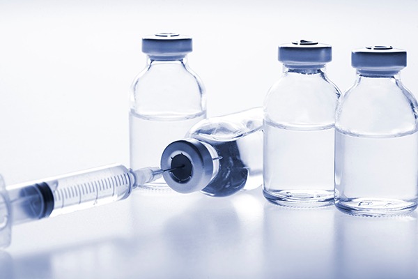 vials of clear liquid with a syringe in one vial