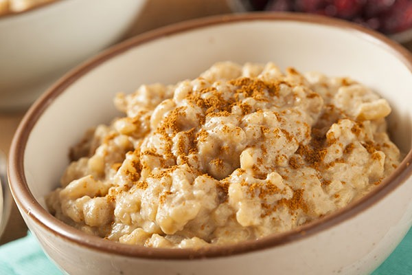 Bowl of brown rice pudding with cinnamon.