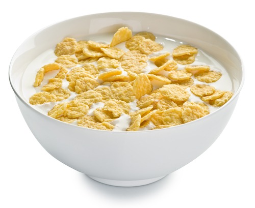 corn flakes in milk in white bowl