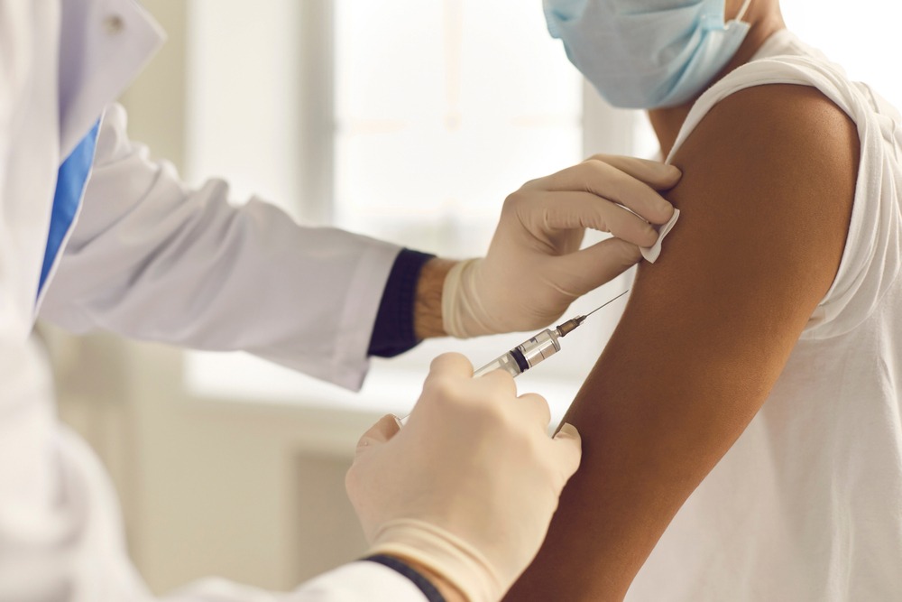 A man getting an injection in his upper left arm.