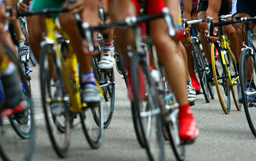 close up of group of cyclists wheels and feet