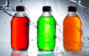 Colorful liquids in plastic bottles getting hit by water.