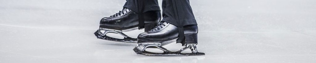 close up of male figure skater's skates on ice