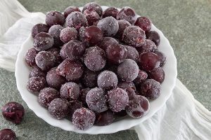 Frozen purple grapes in a bowl.