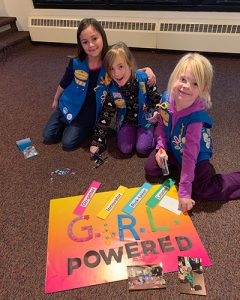 young girl scouts making a poster