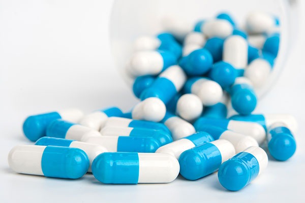 blue and white capsules on white background