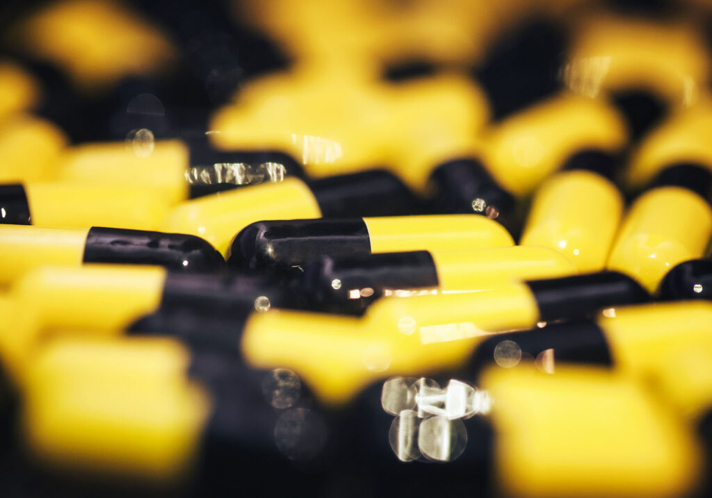Yellow and black pills closeup.