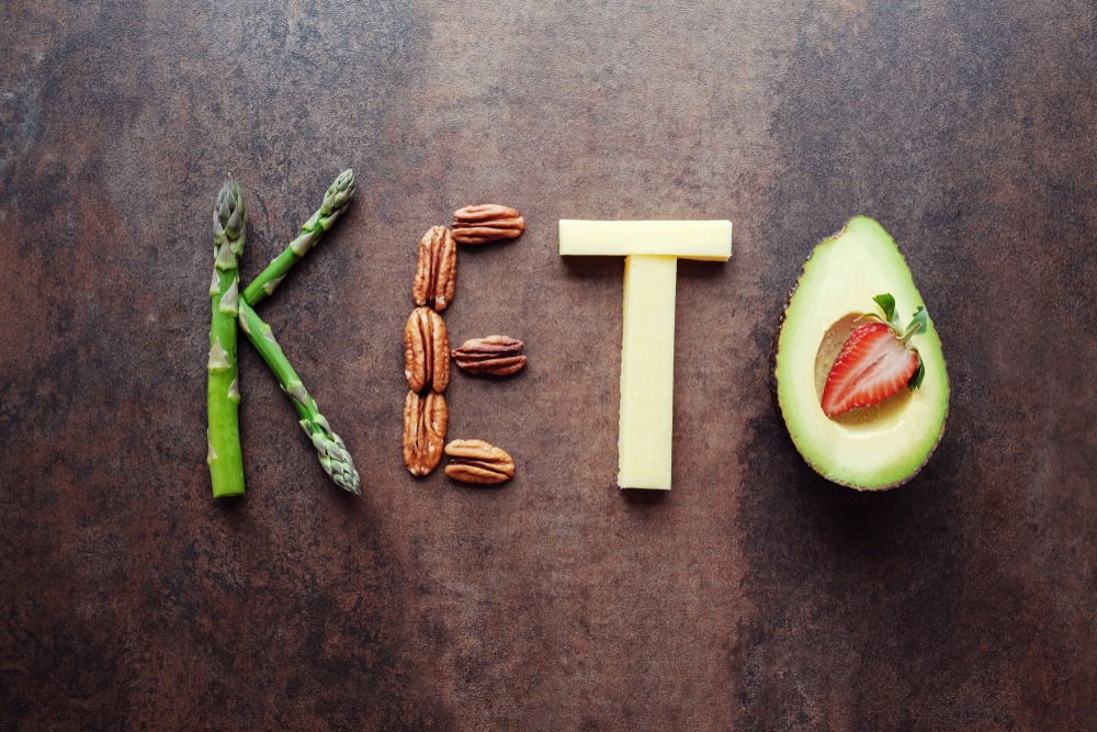 Vegetables, nuts, cheese, and avocado in the shape of the word "KETO."