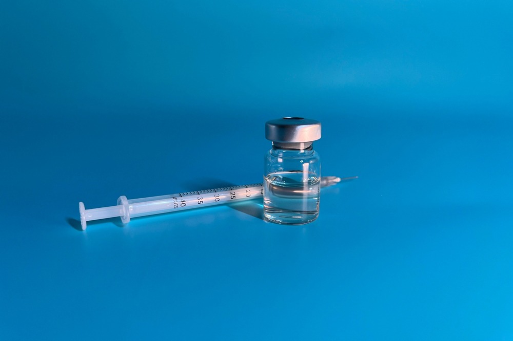 Peptide container next to a syringe.