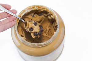 Spoon in a jar of peanut butter with chocolate chip cookies mixed in.