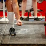 man lifting heavy barbell