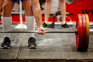 man lifting heavy barbell