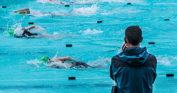 Swimming coach watching swimmers.