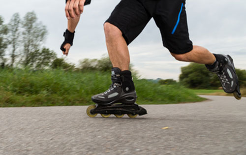 Close up of a man inline skating outside.