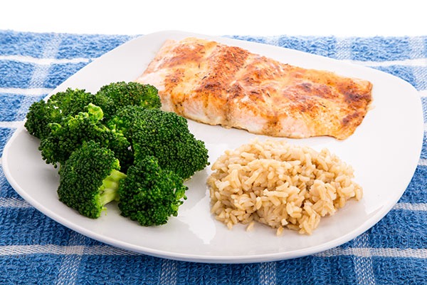 Plate of grilled salmon with brown rice and steamed broccoli