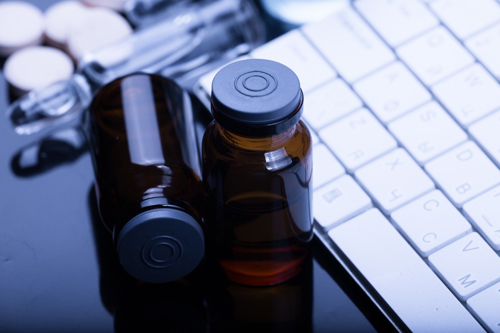 Glass vials next to a computer keyboard.