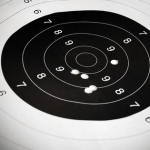 image of paper target full of bullet holes