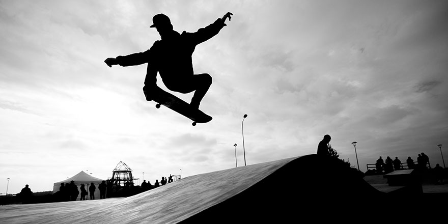 Silhouette of a man skateboarding in a skate park.