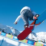 snowboarder in mid-air over half pipe