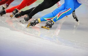 speedskaters going around a corner on the ice track