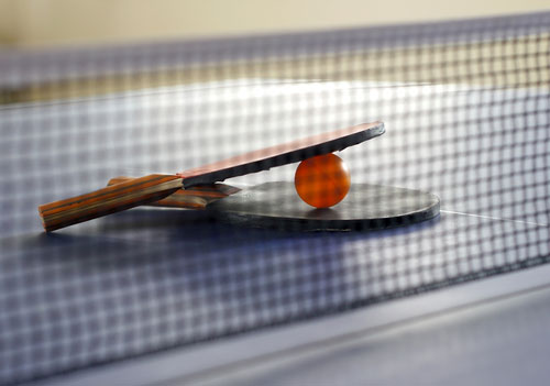 table tennis paddles with ball on table