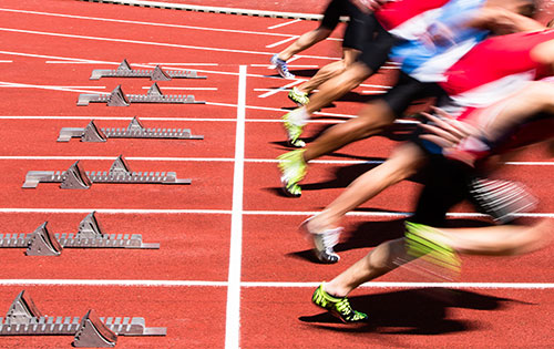 track and field athletes immediately after leaving the start line in a race