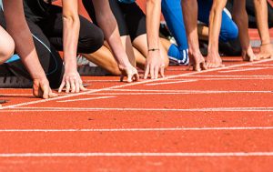 multiple athletes at the starting line of a track and field race