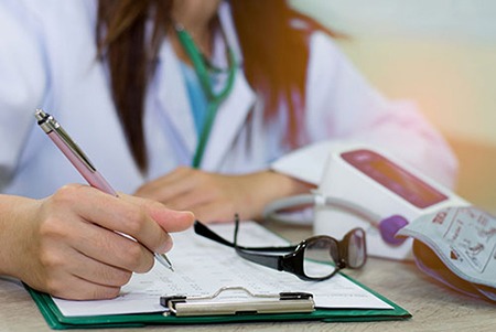 Female doctor writing on a clipboard