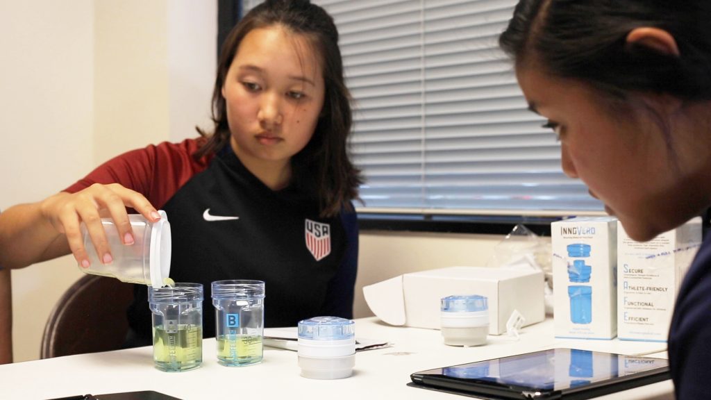 Youth athlete pouring urine into a collection vessel.