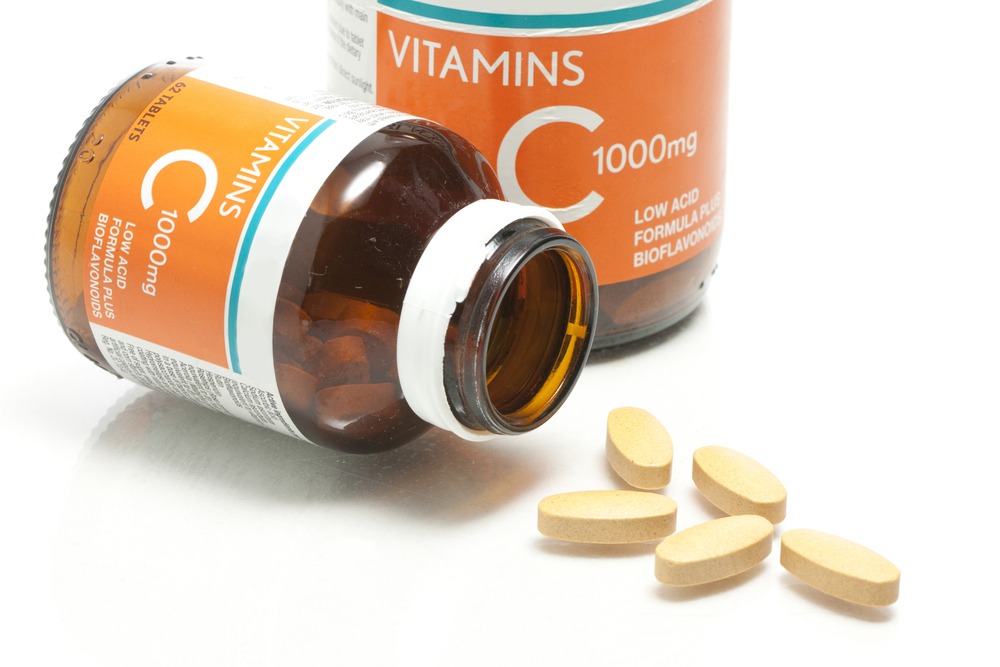 Vitamin C supplement pills coming out of the bottle.