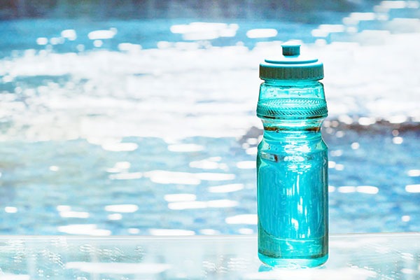 blue water bottle next to pool