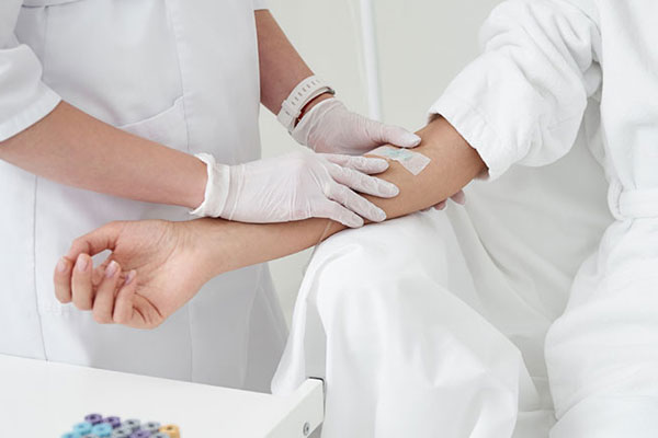 woman in robe receiving IV infusion at wellness clinic