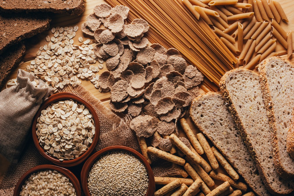 A table featuring a variety of whole grains including bread, pasta, and crackers.